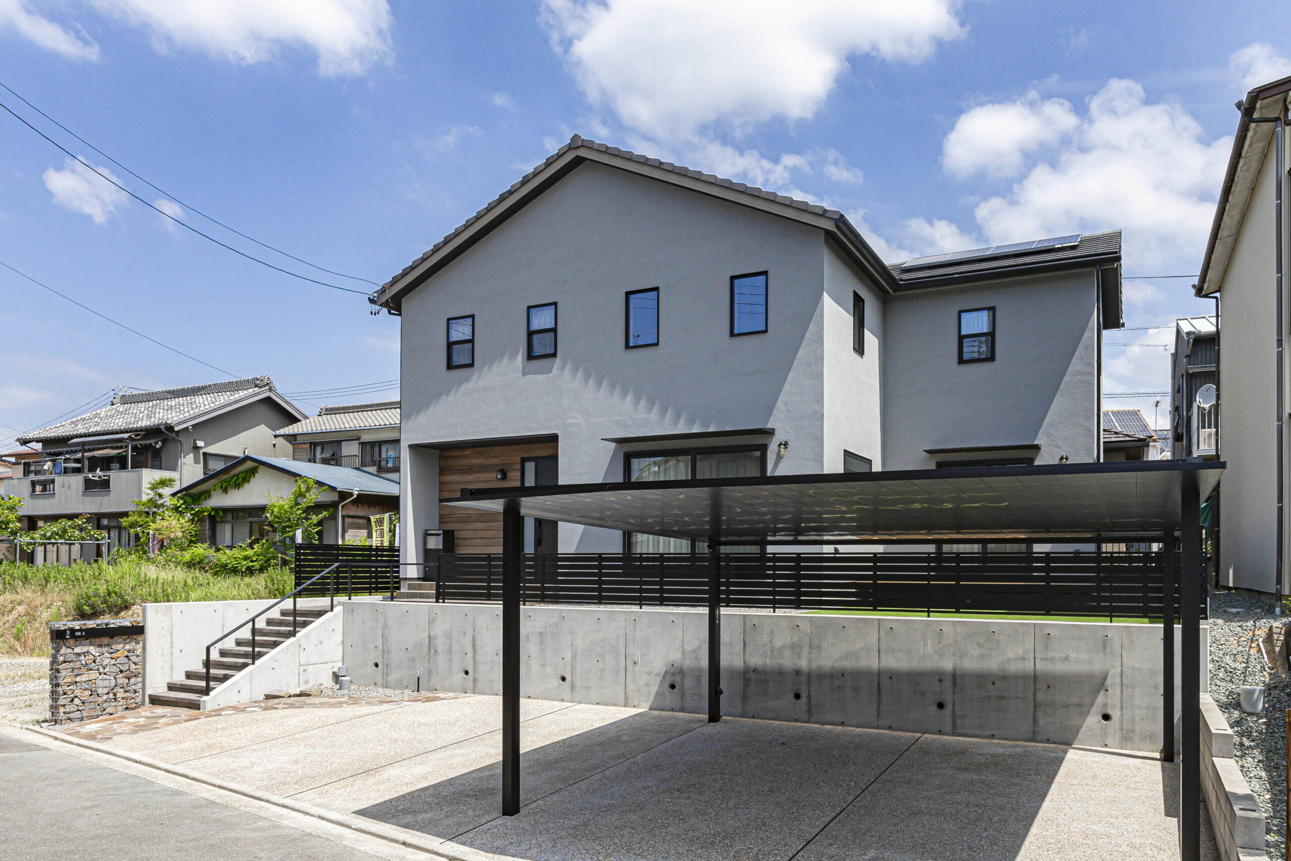 豊橋市に建つYKKAPのカーポートと高低差を活かしたアメリカンな外観の家