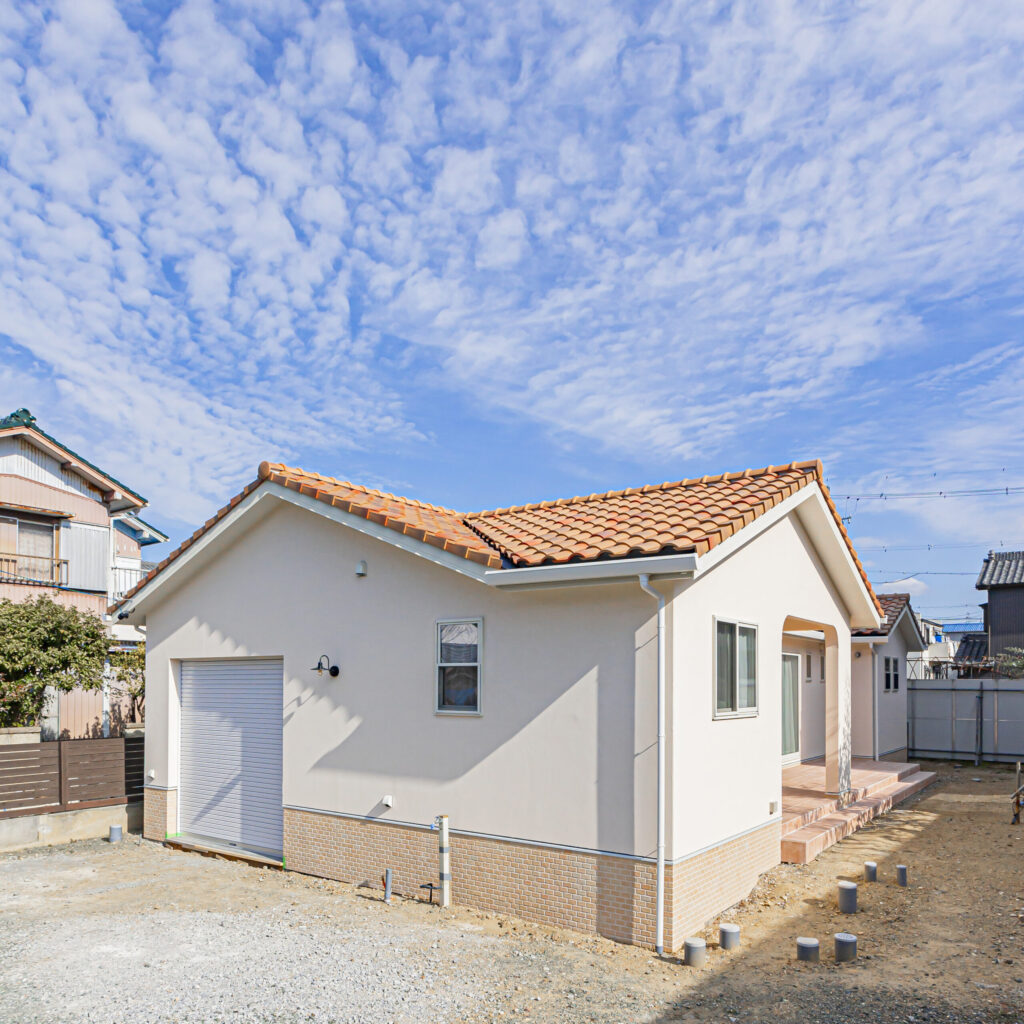 白い塗り壁と明るい瓦屋根の平屋の外観